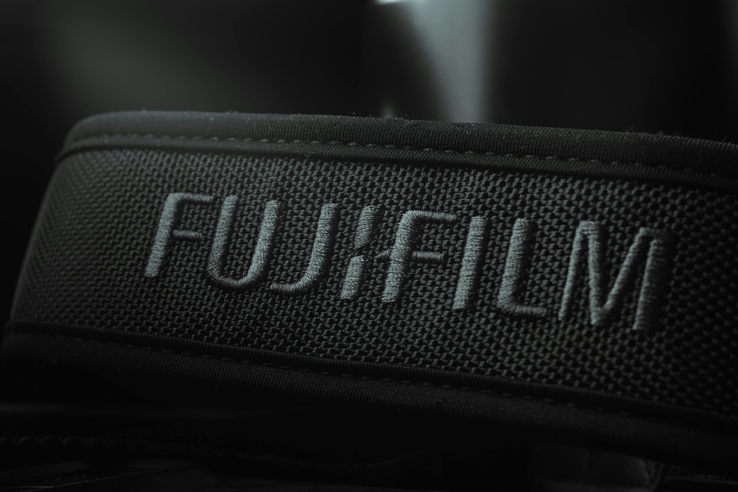 Detailed image of a camera strap featuring the Fujifilm logo in focus.